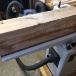 A block of wood rests on the jointer.